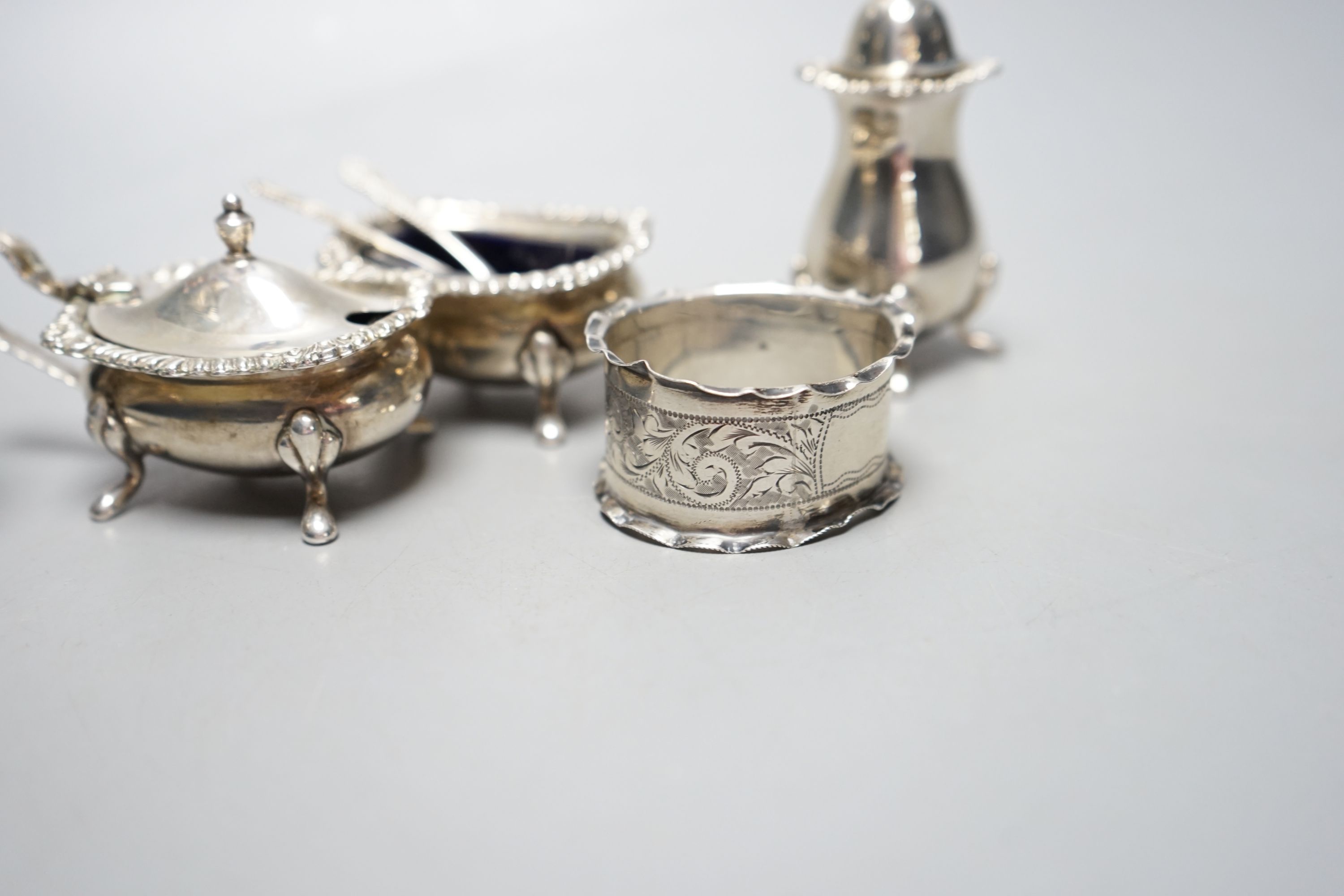 An Edwardian silver sugar sifter, Birmingham, 1901, a silver three piece condiment set and a silver napkin ring.